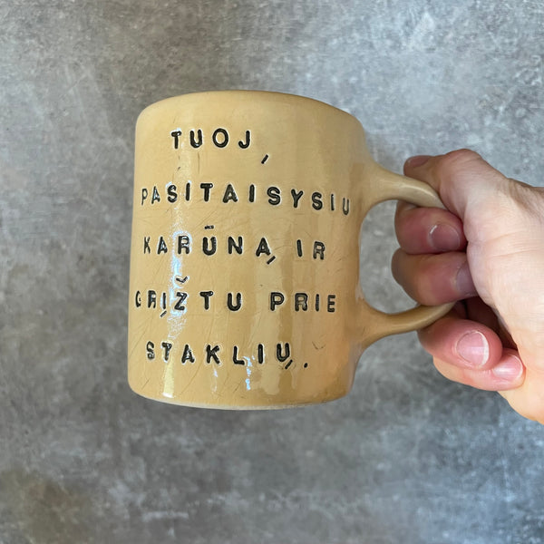 Geltonas puodelis su užrašu