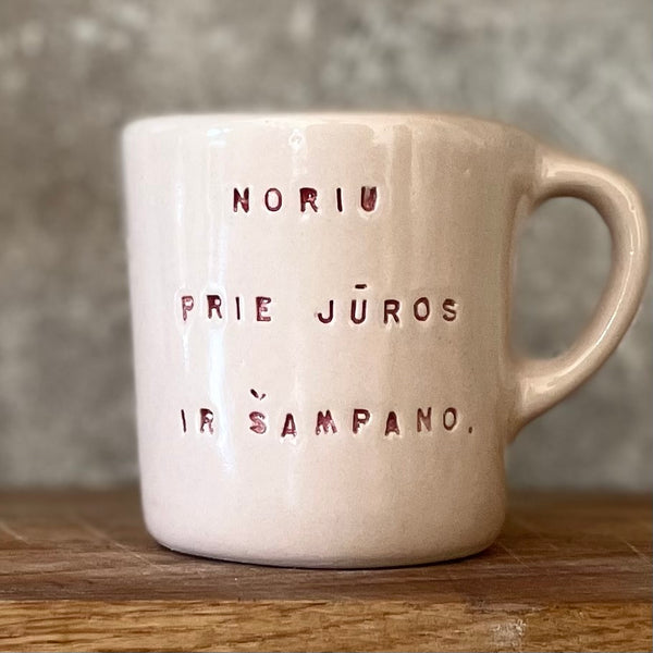 Small pink mug with words in Lithuanian