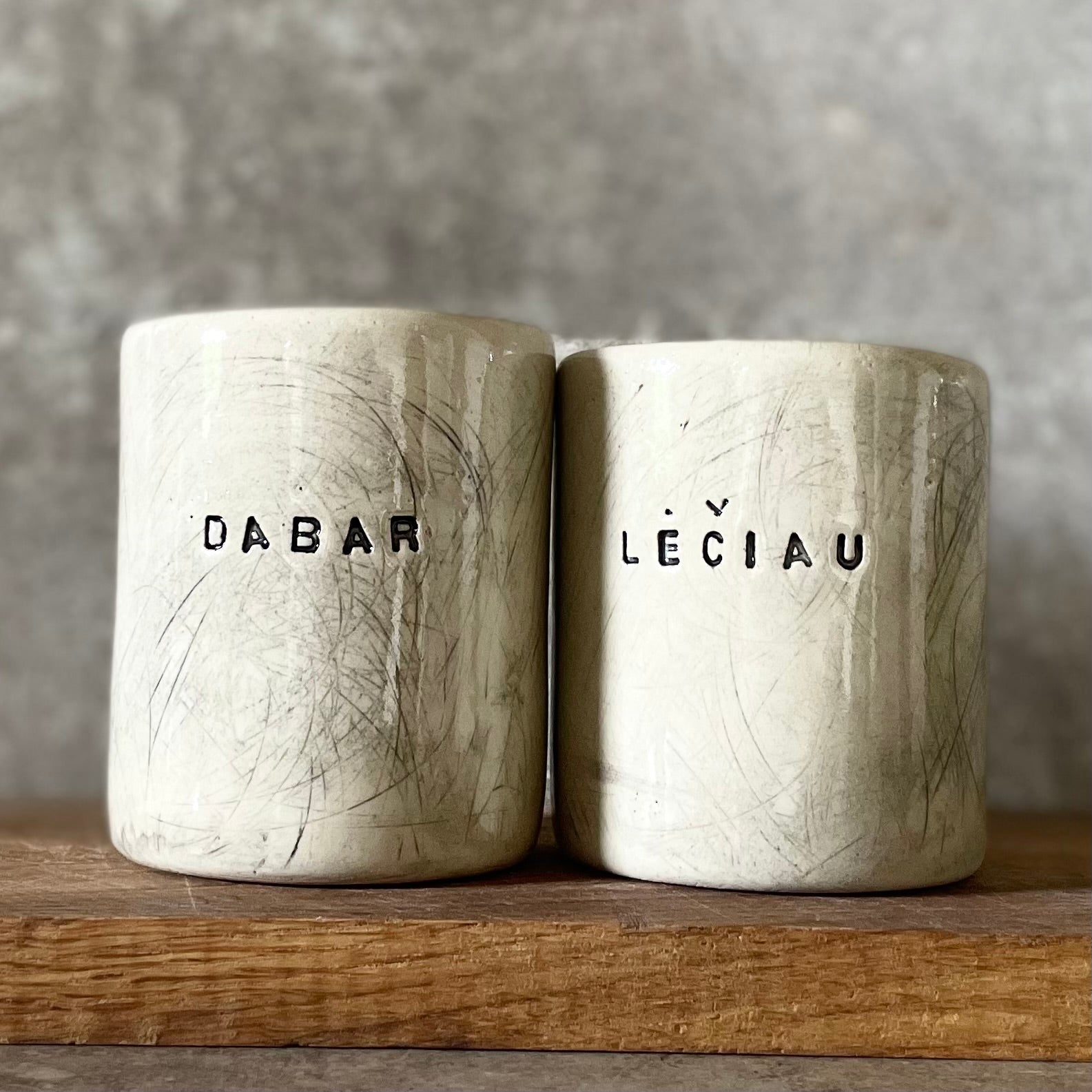 Off-white coffee mugs with words DABAR LĖČIAU