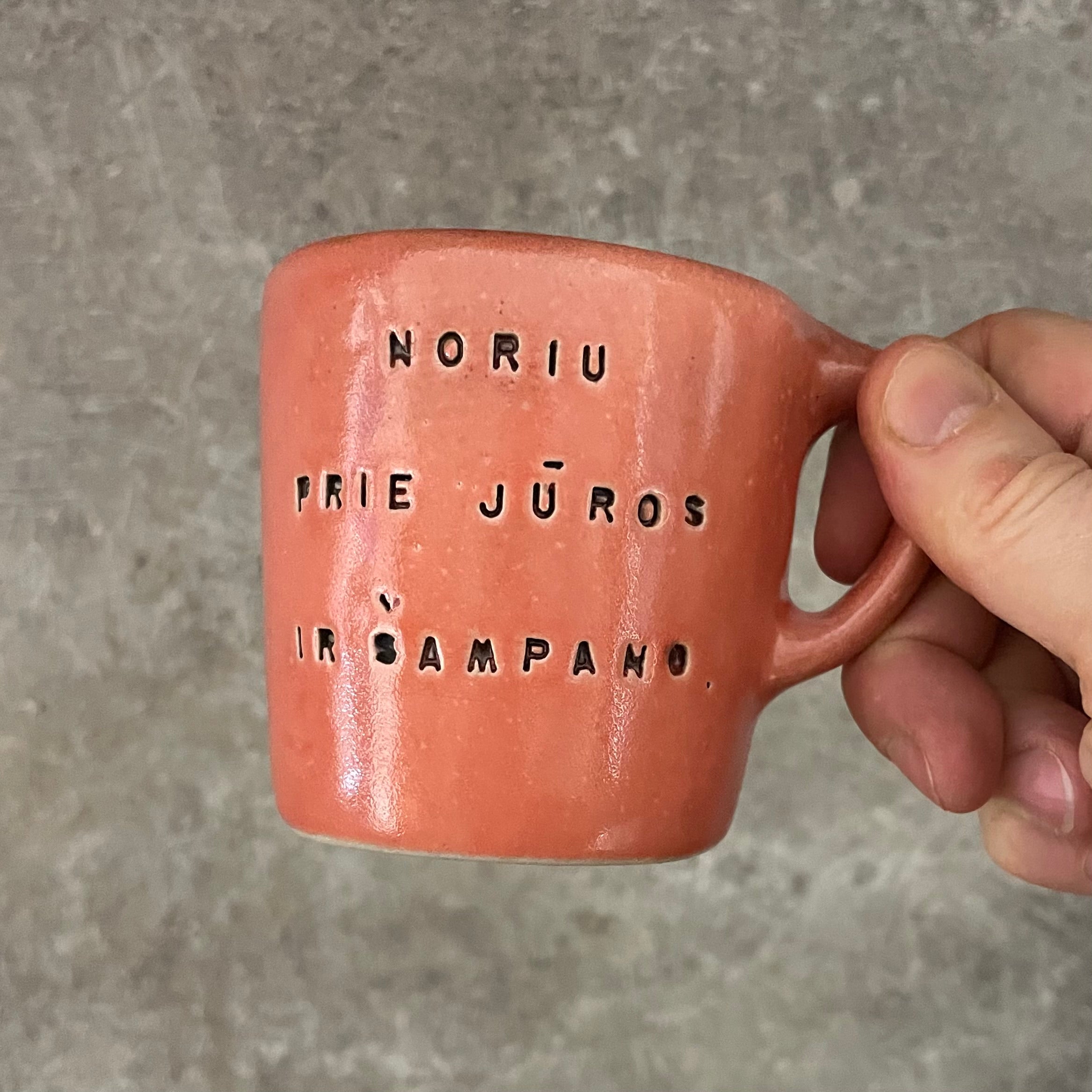 Small red mug with words in Lithuanian