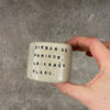 A set of small mugs with words in Lithuanian
