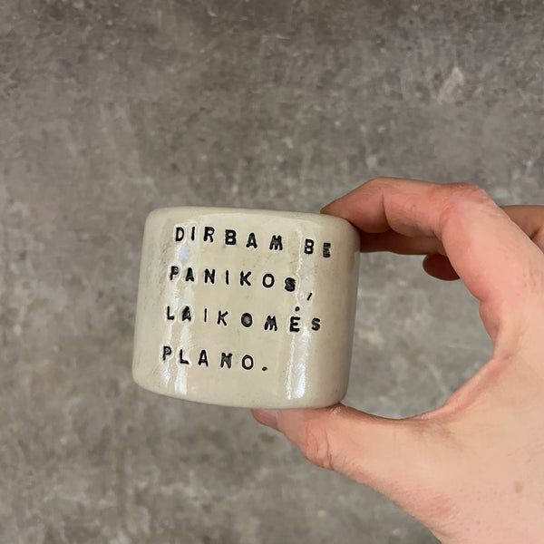 A set of small mugs with words in Lithuanian