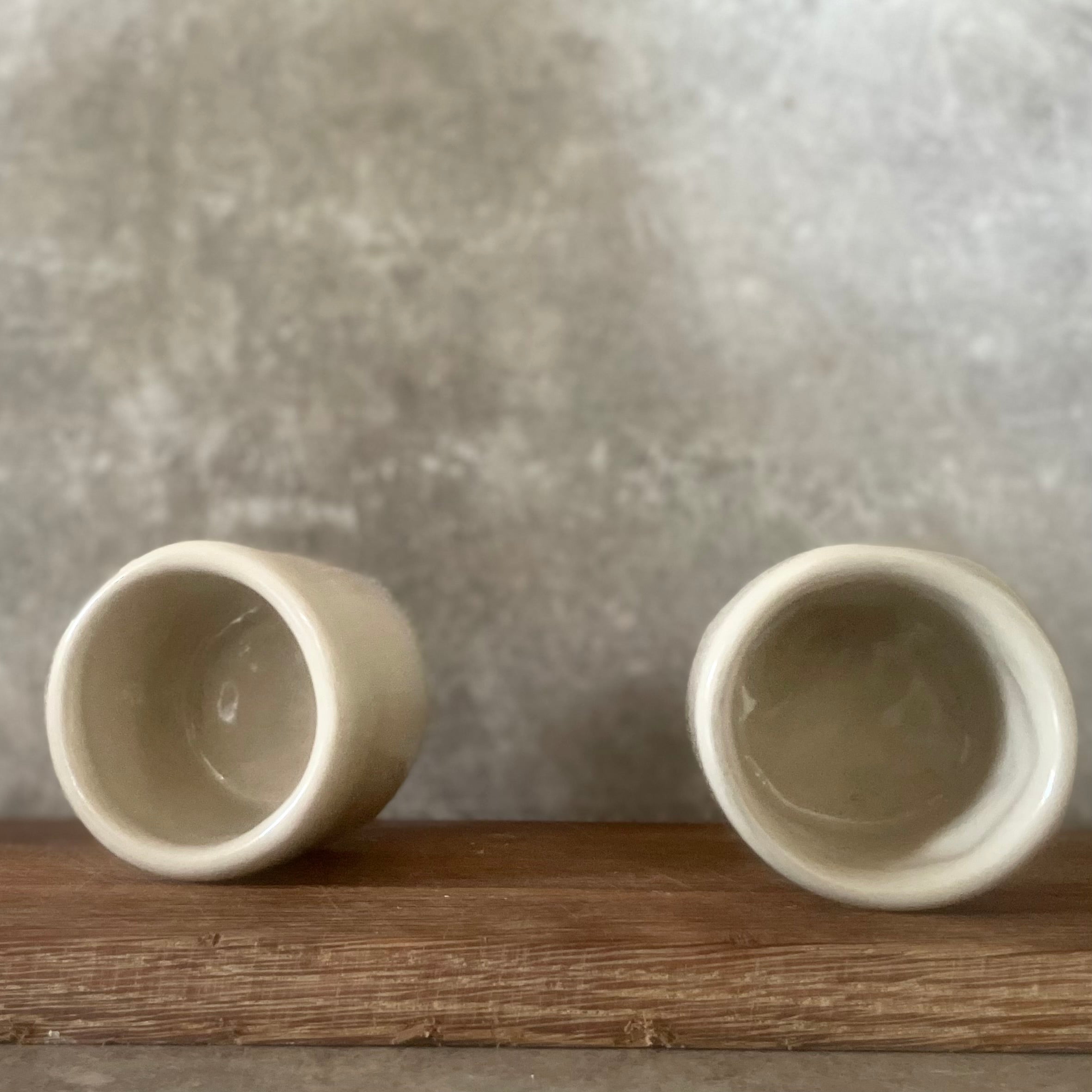 A set of small mugs with words in Lithuanian