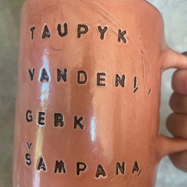 Puodelis su linksmu užrašu apie šampaną