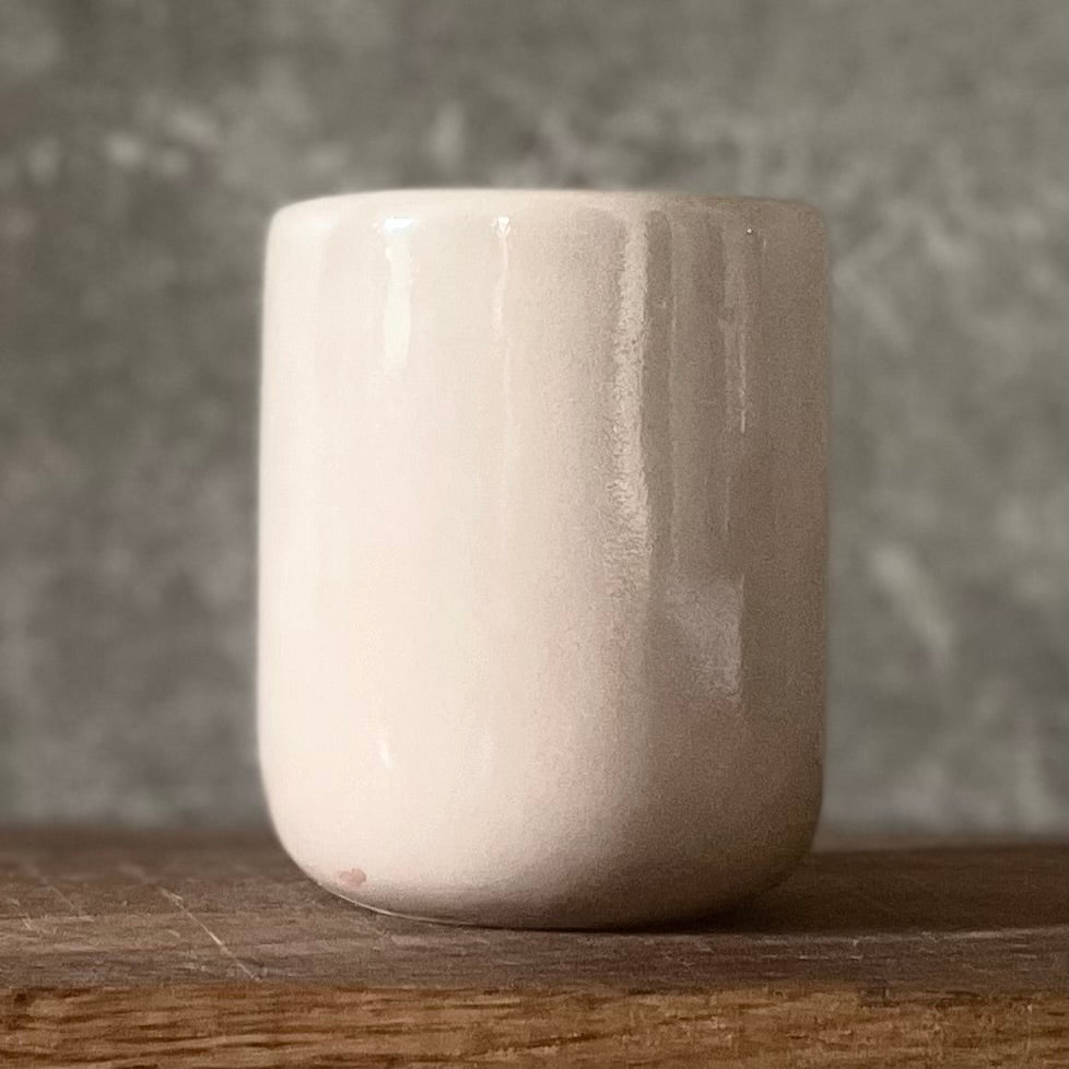 Small pink mug without handle with text in Lithuanian