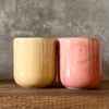 A pair of mugs with words in Lithuanian