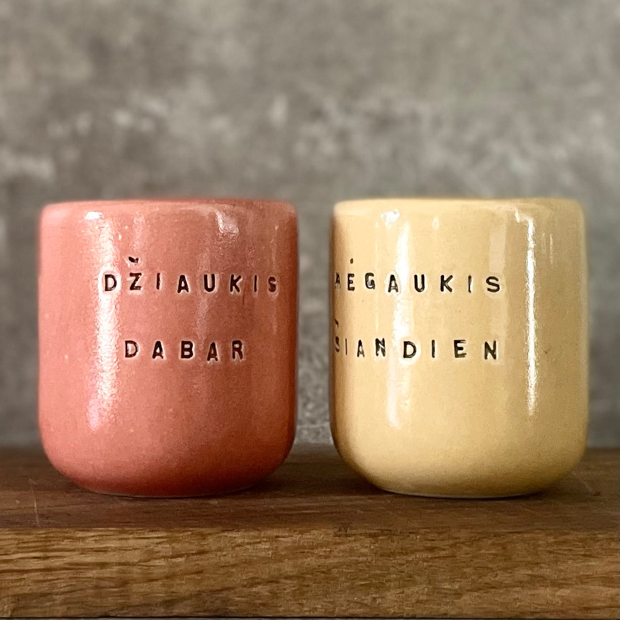 A pair of mugs with words in Lithuanian