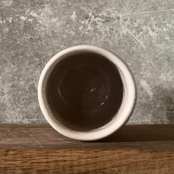 Small pink mug without handle with text in Lithuanian